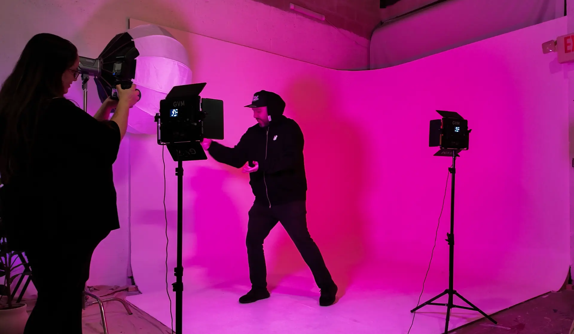 Photographer shooting a pose against the pink cyclorama wall